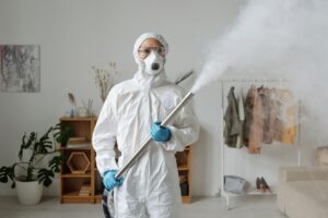 Técnico con equipo de protección aplicando un tratamiento de control de plagas