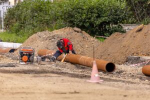 Operario reparando una tubería de saneamiento en obra